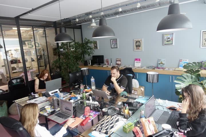 Photo des bureaux de l'agence de relations presse à Paris. On y voit les collaborateurs travaillant autour d'une grande table.